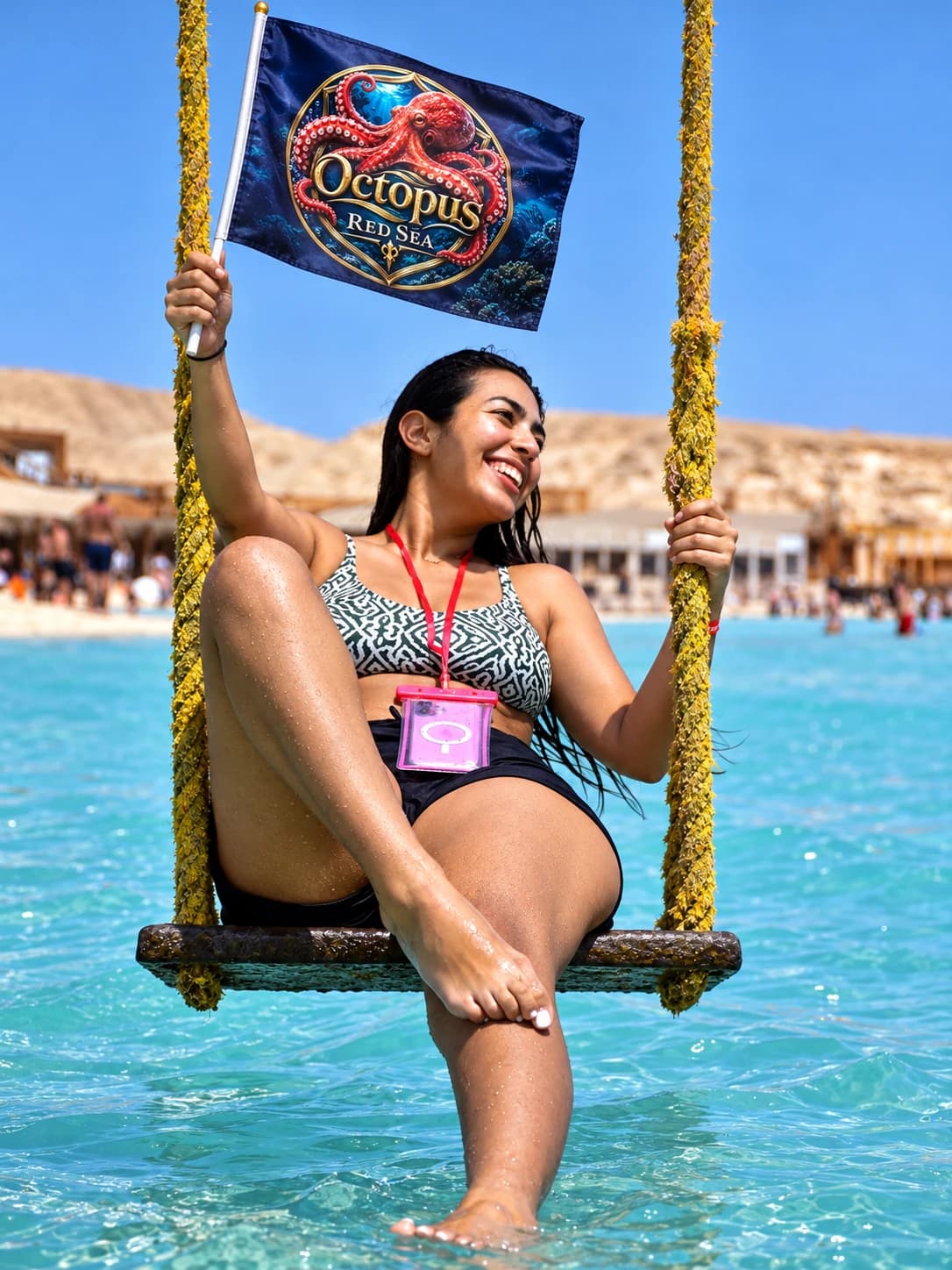 Woman enjoying an island swing while holding an Octopus Red Sea flag